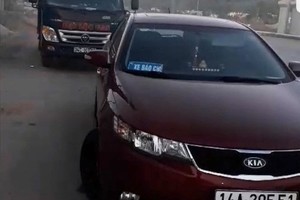 Chiếc KIA dán logo "xe báo chí" chặn đầu xe tải chở gas để kiểm tra. Ảnh: B.M.