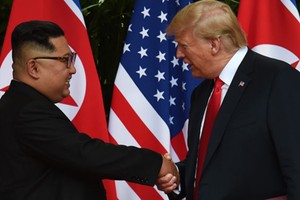 Tổng thống Mỹ Donald Trump và lãnh đạo Triều Tiên Kim Jong-un bắt tay sau khi ký tuyên bố chung. Ảnh: Reuters.