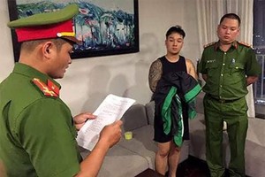 Nhà chức trách đọc lệnh bắt một người trong đường dây đánh bạc. Ảnh: Cơ quan điều tra Bộ Công an.