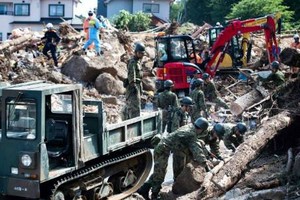 Lực lượng cứu hộ và binh sĩ dọn dẹp đống đổ nát trên một con phố sau trận lụt ở Kumano, tỉnh Hiroshima, ngày 9/7. Ảnh: AFP.