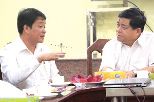Bộ trưởng Bộ Kế hoạch và Đầu tư Nguyễn Chí Dũng (bên phải) trao đổi với đại diện Công ty Cát Tường.