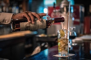 Một nhân viên pha chế đang làm cocktail với rượu rum tại Venezuela. Ảnh: Bloomberg.