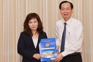Phó Chủ tịch Thường trực UBND TPHCM trao quyết định cho bà Huỳnh Thị Thanh Hiền. Ảnh SGGP.