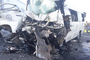 Chiếc xe ô tô 16 chỗ bị dập nát phần đầu khi va chạm với xe container.