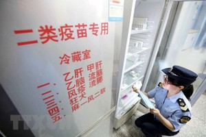 Nhân viên thực thi pháp luật thuộc Cơ quan quản lý và giám sát thị trường kiểm tra việc cung ứng vắc-xin tại Dung An, khu tự trị dân tộc Choang Quảng Tây, Trung Quốc ngày 23/7 vừa qua. (Ảnh: EPA/TTXVN).