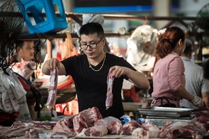 Một người bán thịt lợn tại chợ ở Chu Gia Giác. Ảnh: Washington Post.