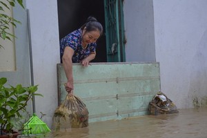 Người dân chặn khỏi nước ngập vào nhà. (Ảnh: Xuân Tư/TTXVN).