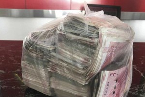 Túi tiền mặt đựng đầy những tờ 100 Nhân dân tệ mà cô Li nhặt được trong đống rác. (Nguồn: SCMP).