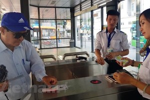 Khách sử dụng thẻ vé điện tử qua cổng kiểm soát để lên xe buýt nhanh BRT 01 Kim Mã-Yên Nghĩa. (Ảnh: Việt Hùng/Vietnam+).