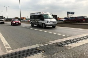 Một số khe con giãn trên cầu bong tróc, xuất hiện ổ gà nham nhở khiến mất an toàn giao thông. (Ảnh: Nguyễn Hằng/Vietnam+).