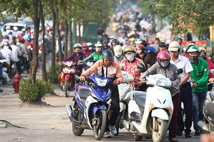 Bị cấm đường, người dân leo lên vỉa hè đường Lê Văn Lươngđi ngược chiều. Ảnh:Ngọc Thành.