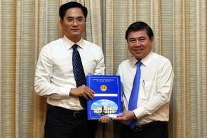 Chủ tịch UBND TP.HCM Nguyễn Thành Phong trao quyết định cho ông Trần Quang Lâm. Ảnh: Trung Sơn