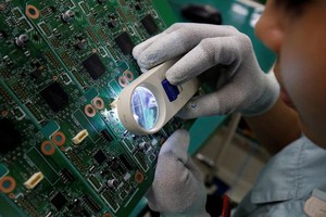 Một công nhân soát lỗi sản phẩm tại nhà máy ở Bắc Ninh, Việt Nam. (Ảnh: Reuters).