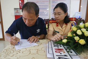 Một tài xế làm thủ tục cấp đổi biển số, sang tên ở Cục Cảnh sát giao thông. Ảnh: Bá Đô.