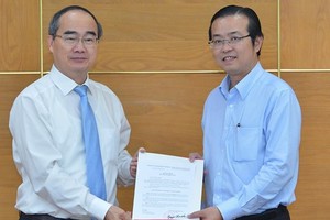 Bí thư Thành ủy thành phố Hồ Chí Minh Nguyễn Thiện Nhân trao quyết định cho đồng chí Lê Văn Minh.