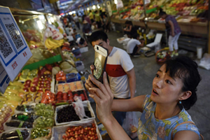 Một khách hàng Trung Quốc đang quét mã QR để thanh toán. Ảnh: VCG.