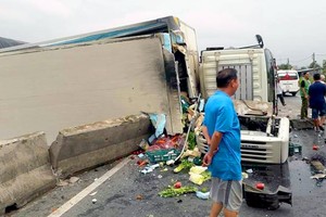 Sau khi tông sập dải phân cách xe tải lật ngang khiến quốc lộ 1 ùn tác cục bộ. Ảnh: B.T.