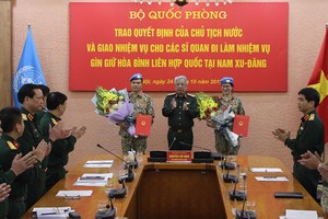 Thượng tướng Nguyễn Chí Vịnh trao quyết định và chúc mừng 2 sĩ quan lên đường làm nhiệm vụ. Ảnh BQP.