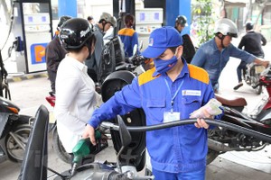 Nhân viên Petrolimex đang bán xăng cho khách hàng. (Ảnh: Đức Duy/Vietnam+).