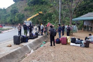 Hành khách đi trên xe và hành lý được đưa ra ngoài. (Ảnh: TTXVN)