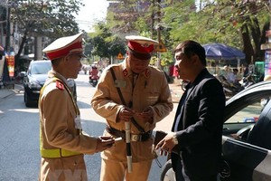 Lực lượng cảnh sát giao thông tỉnh Cà Mau kiểm tra nồng độ cồn của người tham gia giao thông (ảnh chụp đêm 5/1). (Ảnh: Huỳnh Thế Anh/TTXVN)