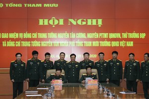 Trung tướng Nguyễn Tân Cương và Trung tướng Nguyễn Văn Nghĩa ký biên bản bàn giao. Ảnh BQP.