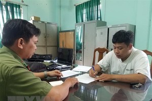 Công an làm việc với Trần Văn Tùng. (Ảnh: TTXVN).