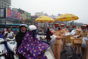 Hình ảnh lực lượng CSGT Hà Nội phát khẩu trang miễn phí cho người tham gia giao thông tại nút giao Xã Đàn - Ô Chợ Dừa.