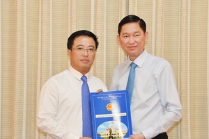 Ông Lê Huỳnh Minh Tú (trái) nhận quyết định bổ nhiệm giữ chức vụ Phó Giám đốc Sở Công thương TPHCM. Ảnh: Sài Gòn giải phóng online.