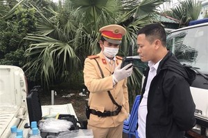 Cảnh sát giao thông kiểm tra nồng độ cồn trong khí thở đối với người điều khiển phương tiện. (Ảnh: Doãn Tấn/TTXVN).