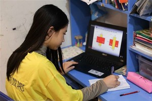 Học sinh lớp 5 trường Tiểu học Vinschool (Hà Nội) luyện tập toán qua bài tập trực tuyến tại nhà. (Ảnh: Thanh Tùng/TTXVN).