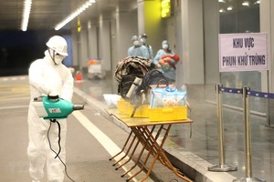 Phun hóa chất khử trùng hành lý của cho công dân Việt Nam trở về từ Vũ Hán (Trung Quốc). (Ảnh: Dương Giang/TTXVN).