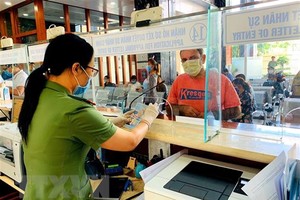 Cán bộ Công an cửa khẩu Tân Sơn Nhất chủ động trang bị đầy đủ khẩu trang, găng tay trong khi làm nhiệm vụ. (Ảnh: Thành Chung/TTXVN).