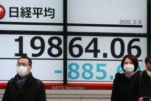 Nhà đầu tư đang theo sát các động thái chống dịch và hỗ trợ kinh tế của các chính phủ. Ảnh: AFP.