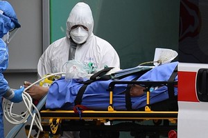 Nhân viên y tế đưa bệnh nhân vào khu hồi sức tích cực tại một bệnh viện ở Milan hôm 23/3. Ảnh: AFP.