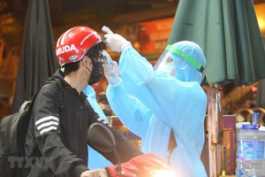 Nhân viên y tế kiểm tra và sát khuẩn cho những người vào bênh viện. (Ảnh: Dương Giang/TTXVN).