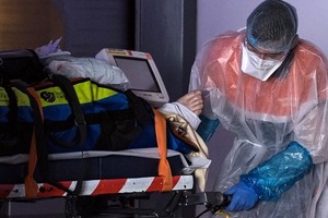 Nhân viên y tế di chuyển bệnh nhân nhiễm nCoV tới một bệnh viện ở Paris, Pháp, ngày 1/4. Ảnh: AFP..