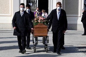 Nhóm người khiêng linh cữu đeo khẩu trang tại đám tang của một phụ nữ chết do nCoV ở Seriate. Italy, hôm 28/3. Ảnh: Reuters. 