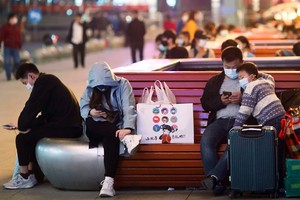 Các hành khách chờ khởi hành tại ga tàu chính ở thành phố Vũ Hán, tỉnh Hồ Bắc, Trung Quốc đêm 7/4. Ảnh: SCMP.