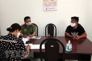 Cơ quan chức năng làm việc với Nguyễn Lập T. (áo đen). (Ảnh: TTXVN phát).