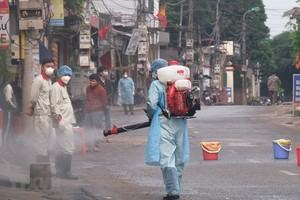 Lực lượng chức năng phun khử khuẩn. (Ảnh: Phạm Hùng/TTXVN phát).