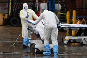 Nhân viên y tế Mỹ đưa thi thể bệnh nhân ra xe đông lạnh tại New York hôm 9/4. Ảnh: AFP.