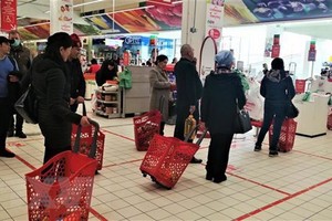 Xếp hàng giãn cách theo vạch kẻ trước quầy thanh toán tại một siêu thị ở thủ đô Moskva (Nga).