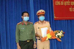 Đại tá Nguyễn Văn Trãi, Giám đốc Công an tỉnh Tây Ninh, trao quyết định bổ nhiệm của Bộ Trưởng Bộ Công an cho Thượng tá Phan Văn Triều (phải).