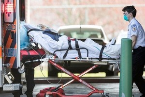 Nhân viên cấp cứu đưa bệnh nhân đi từ viện dưỡng lão ở Chelsea, Anh ngày 17/4. Ảnh: AFP.