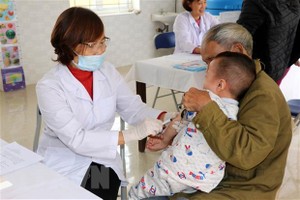 Cán bộ y tế tiêm phòng cho trẻ. (Ảnh: Nguyễn Lành/TTXVN).