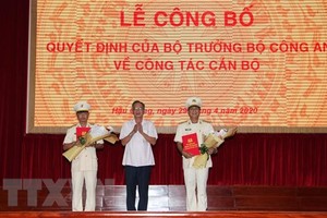 Đồng chí Lữ Văn Hùng, Ủy viên Trung ương Đảng, Bí thư Tỉnh ủy Hậu Giang tặng hoa chúc mừng Thượng tá Huỳnh Việt Hòa và Đại tá Phan Hoàng Lắm. (Ảnh: Hồng Thái/TTXVN).