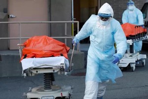 Nhân viên y tế đưa thi thể nạn nhân rời bệnh viện ở New York hồi cuối tháng 4. Ảnh: AFP.