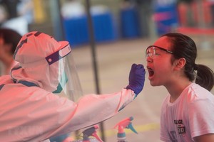 Nhân viên y tế lấy mẫu xét nghiệm COVID-19 cho trẻ nhỏ tại Vũ Hán, tỉnh Hồ Bắc, Trung Quốc ngày 15/5 vừa qua. (Ảnh: THX/TTXVN).