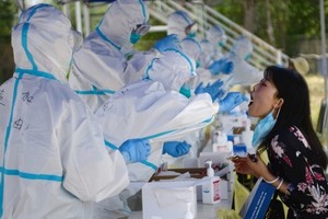 Nhân viên y tế lấy mẫu xét nghiệm nCoV cho một người dân ở thủ đô Bắc Kinh, Trung Quốc, ngày 20/6. Ảnh: Reuters.